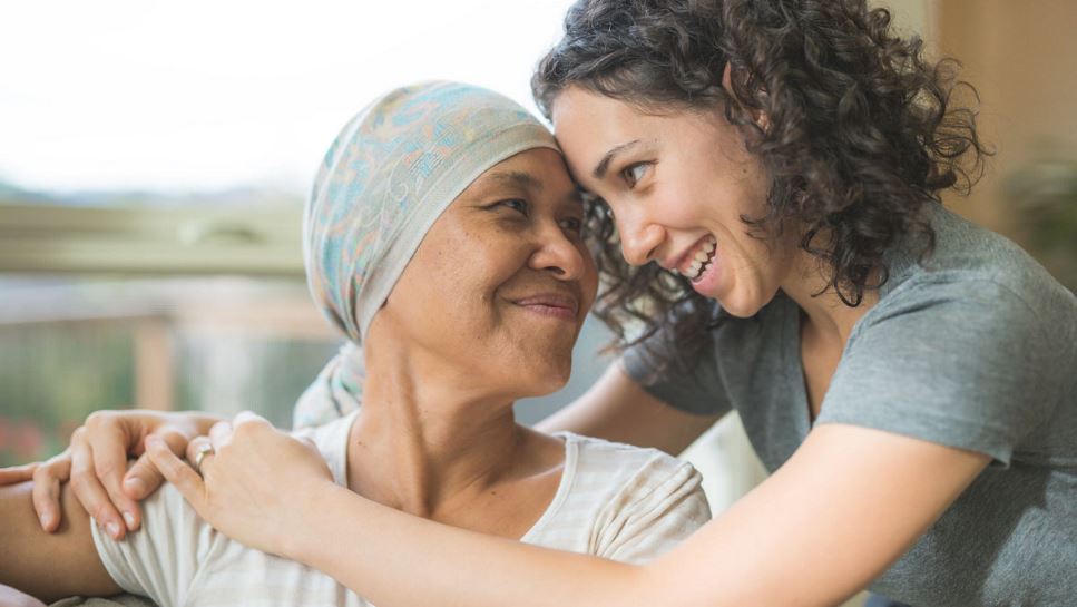 A cancer patient and her daughter hug.